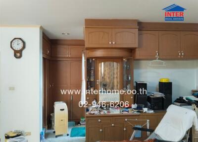 Living area with wooden cabinetry, clock, and various items
