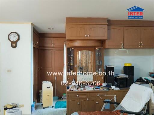 Living area with wooden cabinetry, clock, and various items