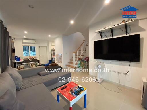 Modern living room with gray sectional sofa and wall-mounted TV