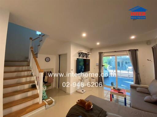 Modern living room with staircase and large windows