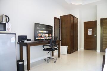 Living area with workspace featuring a TV and office chair