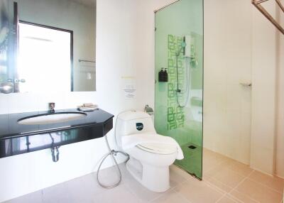 Modern bathroom with glass shower, toilet, and sink