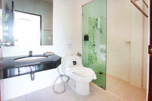 Modern bathroom with glass shower, toilet, and sink