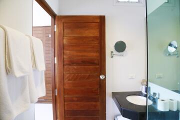 Modern bathroom with wooden door and black countertop