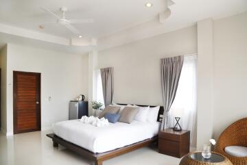 Modern bedroom with a large bed, side tables, a wooden door, and curtains