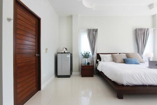 Modern bedroom with wooden door and bed