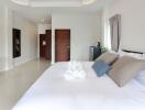 Spacious bedroom with minimalist decor, large bed, and modern amenities