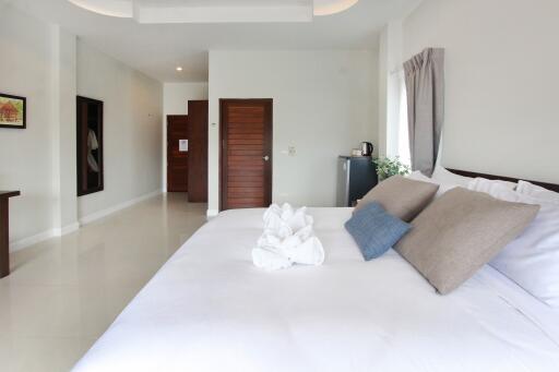 Spacious bedroom with minimalist decor, large bed, and modern amenities