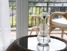 Glass vase with flower on table beside window overlooking outdoor seating