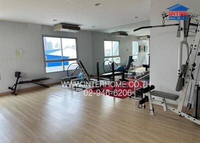 Modern fitness center with gym equipment and large windows
