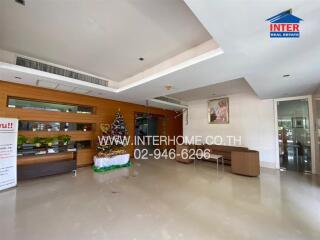 Lobby area with chairs, desk, Christmas decorations, and website contact information