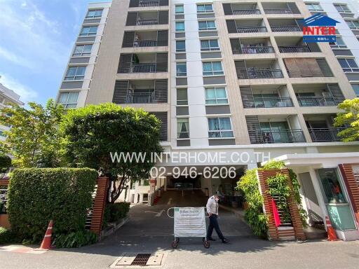 Front view of a residential building with a security guard at the entrance