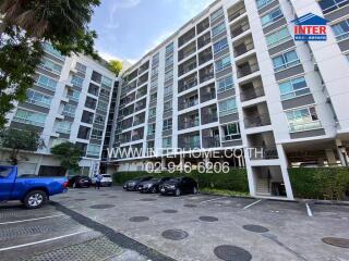 Exterior view of a modern apartment building with parking area