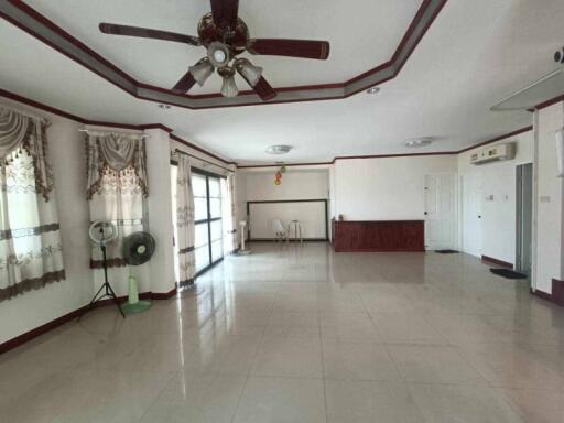 Spacious living room with ceiling fan and large windows