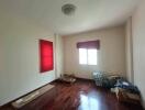 Small unfurnished bedroom with red blinds