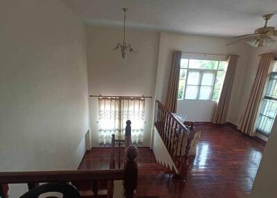 View of a living room with wooden flooring and an upper landing