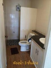 Bathroom with toilet, sink, vanity, and tiled shower area