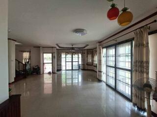 Spacious living room with large windows and tiled floor