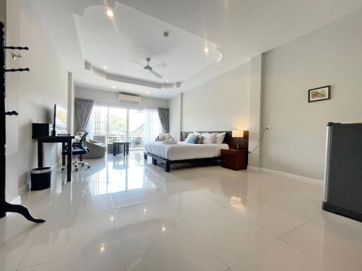 A spacious modern bedroom with large windows and contemporary furnishings