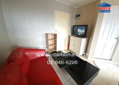 Modern living room with red sofa, TV, and storage furniture