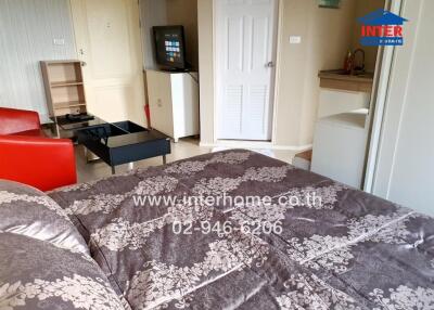 Comfortable bedroom with TV and small kitchen area