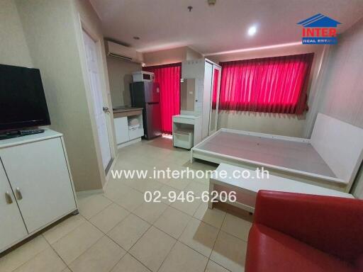 Studio apartment with bed frame, kitchenette, and red curtains