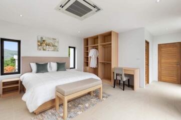 Modern spacious bedroom with minimalist decor, natural light, and built-in wardrobe