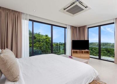 Spacious bedroom with large windows offering a beautiful view