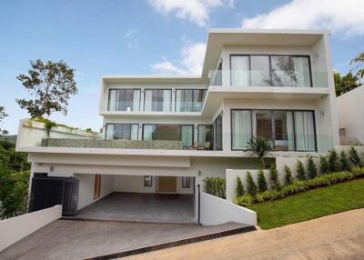 Modern multi-story house with large glass windows and balconies