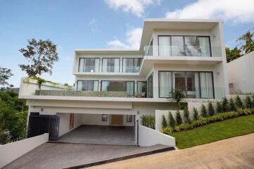 Modern multi-story house with large glass windows and balconies