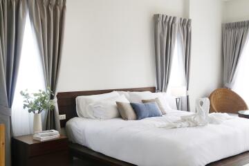 A well-lit bedroom with large windows and modern decor