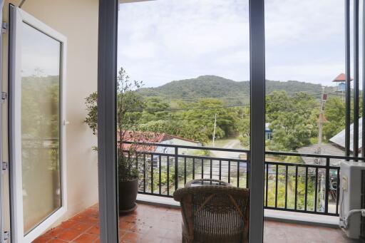 A cozy balcony with a beautiful view of lush green hills