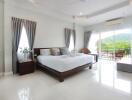 Spacious bedroom with a large bed, balcony view, and ample natural light