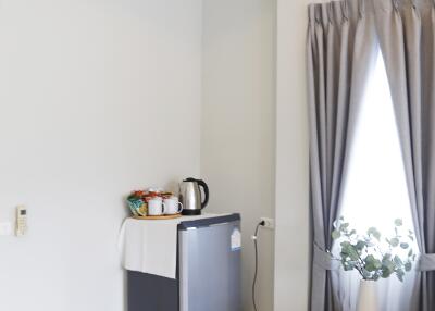 Cozy bedroom corner with mini fridge and window