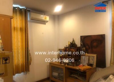 Small bedroom with golden curtains and air conditioning