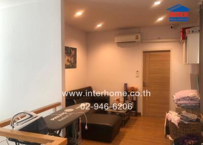 Living room with black sofa, wooden floor, and modern lighting