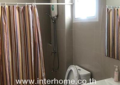Modern bathroom with shower and striped curtain