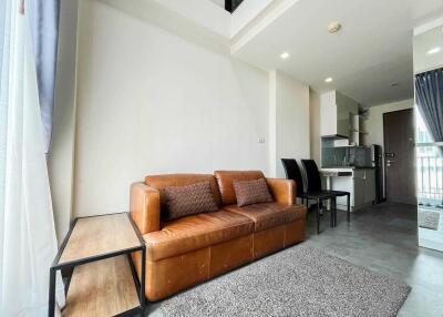 Spacious living area with a brown leather sofa and modern furnishings