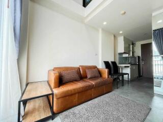 Spacious living area with a brown leather sofa and modern furnishings