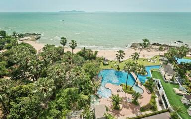 Aerial view of a beachfront property with swimming pool and palm trees