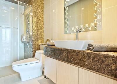 Modern bathroom with glass shower, toilet, and stylish sink