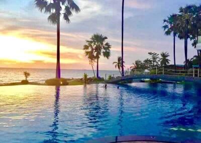 Sunset view of a pool with palm trees