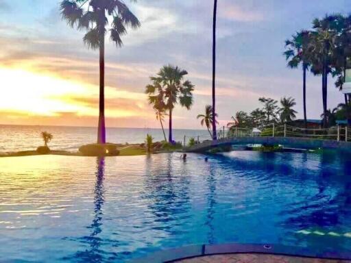 Sunset view of a pool with palm trees