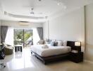 Spacious modern bedroom with large bed, balcony access, and natural light