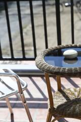 Wicker table and metal chair on balcony