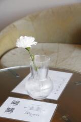 Glass vase with white flower on a table