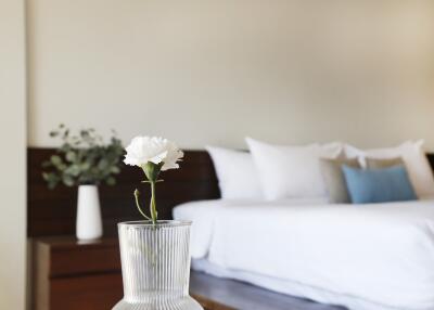 Modern bedroom with a neatly made bed and flower vase