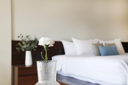 Modern bedroom with a neatly made bed and flower vase