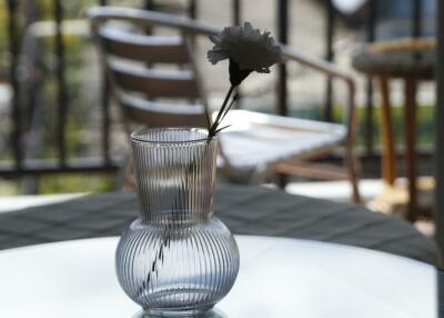 Glass vase with flower on table on balcony