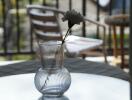 Glass vase with flower on table on balcony